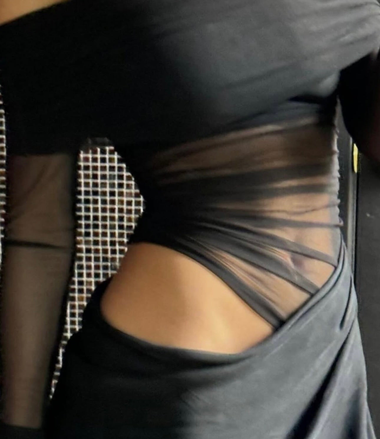Gray dress with sheer detailing on a blurred background